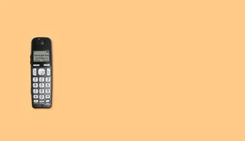 Old wireless push button telephone on orange background Top down view of o... Stock Photos