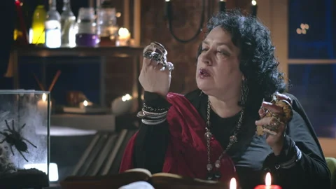 Old witch holding two snakes performing ritual Stock Footage 136884086