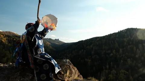 The old wizard knocks on the drum and communicates with the spirits of the Video stock 119458476