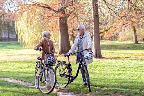 Old woman and man in park with bikes Stock Photos