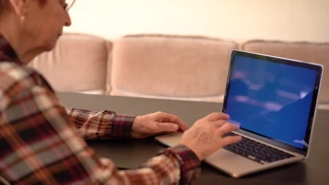 Old woman eighty years old sitting with laptop Stock Footage 252826464