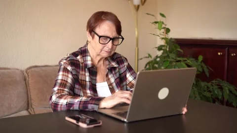 Old woman eighty years old sitting with laptop Stock Footage 253184146