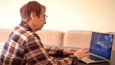 Old woman eighty years old sitting with laptop Stock Footage 253501361