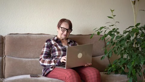 Old woman eighty years old sitting with laptop Stock Footage 253501504