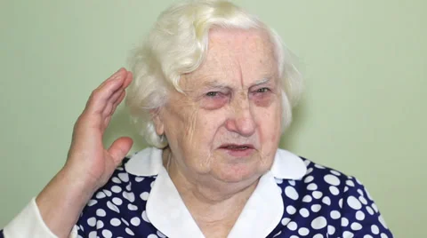 Old woman has a hearing problem and  installing hearing aid. Stock Footage 33989894