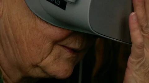 Old woman interacting for first time with virtual reality technology Vr Goggle Video stock 112083881