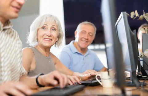 Old woman learning computer programs in training room Foto stock
