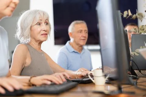 Old woman learning computer programs in training room 库存照片