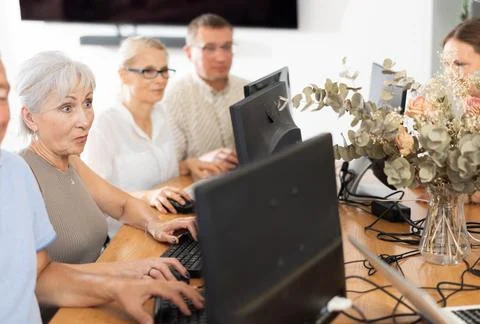 Old woman learning computer programs in training room 스톡 사진