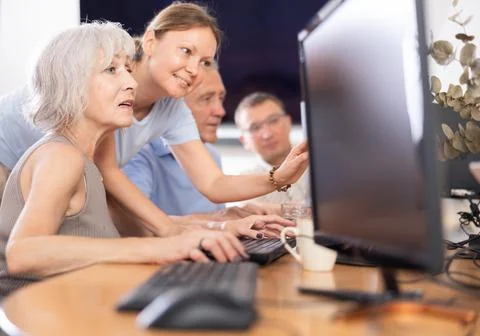 Old woman learning computer programs with teacher in training room 스톡 사진