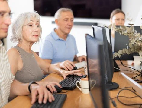 Old woman learning computer programs in training room 스톡 사진