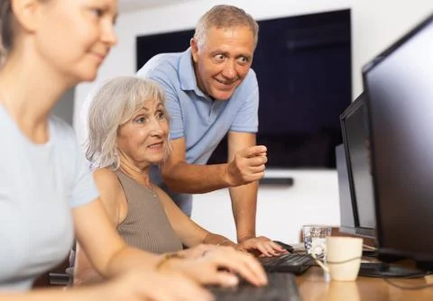 Old woman learning computer programs with teacher in training room 스톡 사진
