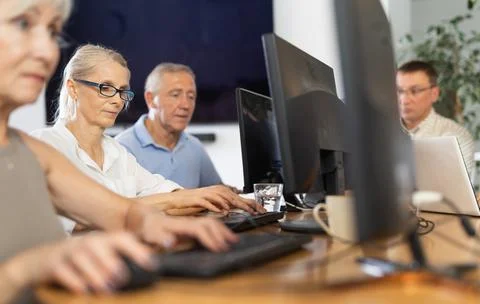 Old woman learning computer programs in training room 스톡 사진