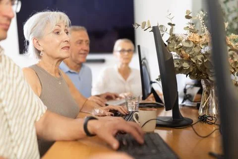 Old woman learning computer programs in training room 스톡 사진