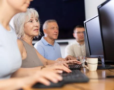 Old woman learning computer programs in training room 스톡 사진