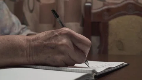 An old woman making notes in a notebook. Hands close-up. 스톡 동영상 254488109