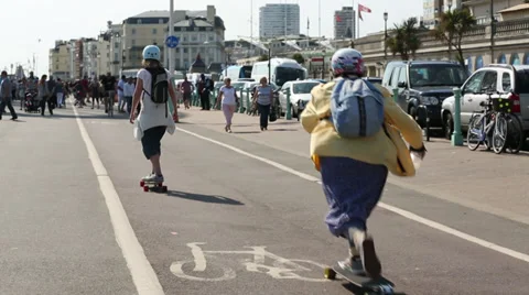 Old Woman Skateboarding down Brighton Promenade Stock Footage
