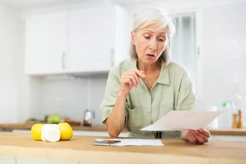 Old woman solving bill problem at home Foto stock