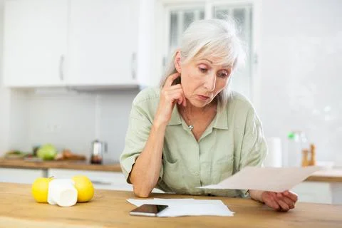 Old woman solving bill problem at home Foto stock