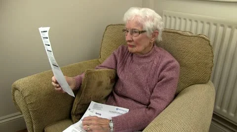 An old woman sorting through her bills Stock Footage 20452278
