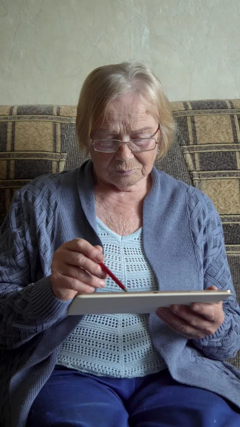 Old woman using digital tablet at home Stock Footage 314788449