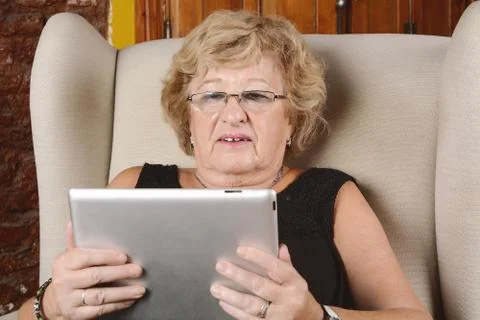 Old woman using tablet. Stock Photos