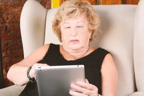 Old woman using tablet. Stock Photos