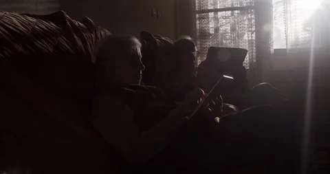Old woman is using a tablet while her husband reads newspapers SLOW MOTION Stock Footage 101955827