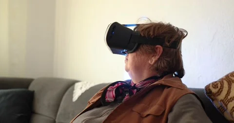 An old woman using Virtual reality headset. Handheld 4K Video Stockbeeldmateriaal 169180370