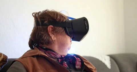An old woman using Virtual reality headset. Handheld 4K Video Stockbeeldmateriaal 169180447