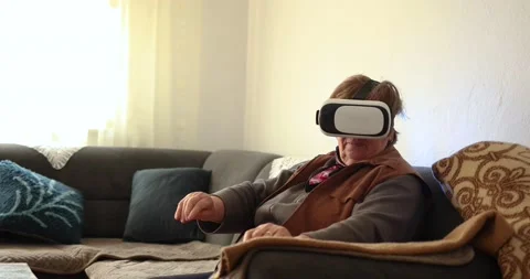An old woman using Virtual reality headset. Handheld 4K Video Stockbeeldmateriaal 169180794