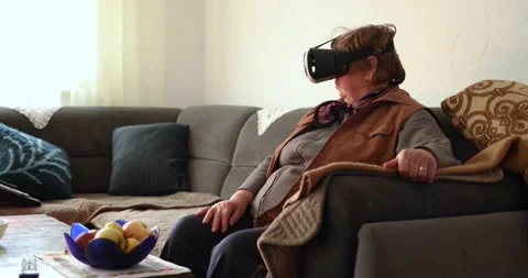 An old woman using Virtual reality headset. Handheld 4K Video Stockbeeldmateriaal 169180877