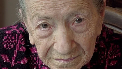 Old woman's closeup portrait looking directly the camera with intense gaze Stock Footage 74492912