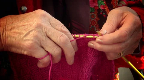Old woman's hand knitting red red wool; closeup footage Stock Footage 64277145