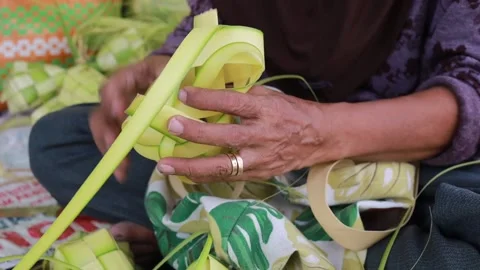 Old Woman's hand making ketupat rice cake using palm leaf for eid fitr Stock Footage 239064531