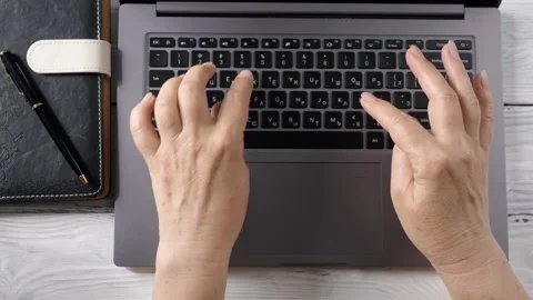 Old woman's hands are typing the text on the laptop. Stock Footage 153992672