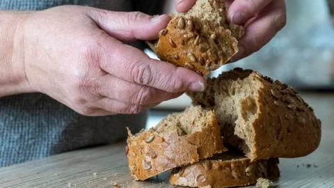 Old woman's hands breaking bread Stock Photos