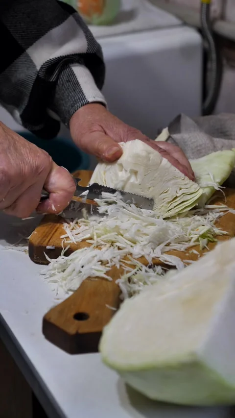 An old womans hands cut cabbage into thin strips with a special salad knife. An Stock Footage 319264732