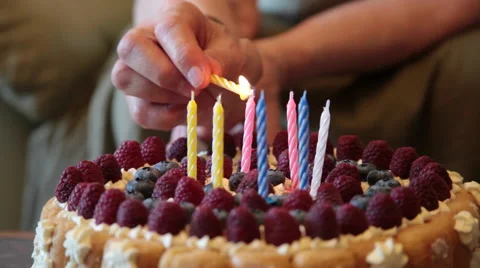 Old woman's hands lighting birthday candles, cake, fruits, cream Stock Footage 53220937