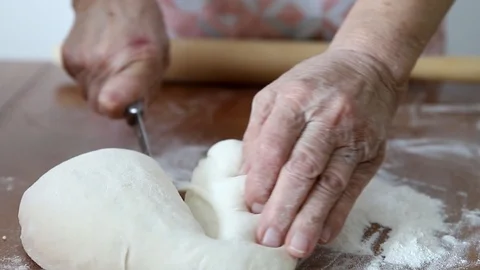Old woman's hands roll out the dough on the table Stock Footage 119280555