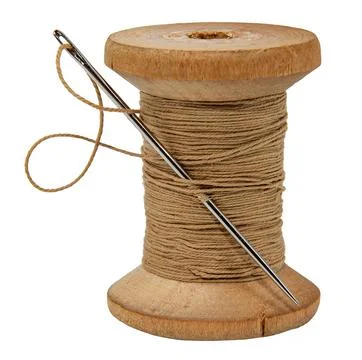 Old wood spool of thread and needle on a white background. Sewing accessories Stock Photos