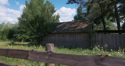 Old wooden barn behind a rustic fence in the countryside Stock Footage 340196052