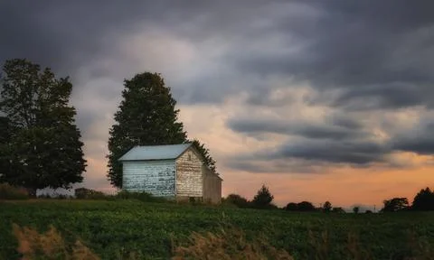 Old  wooden barn at sunset with dramatic sky Stock Photos