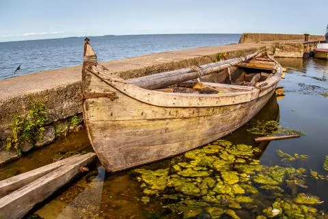 Old wooden boat stands near the pier. Stock Photos