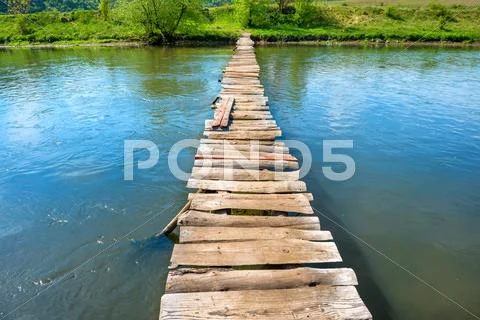 Old wooden bridge through the river Stock Photos