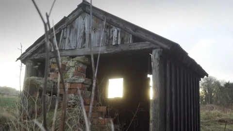 Old wooden cabin supported by bricks surrounded by grass Stock Footage 169048888