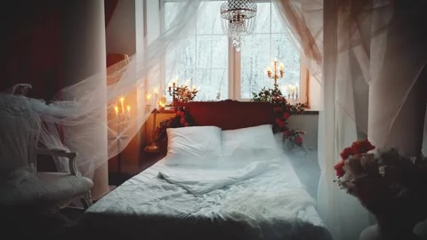 Old wooden canopy bed stands by window, candles burning cozy bedroom vintage Stock Footage 310305909