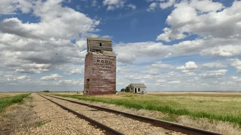 Old wooden grain elevator next to train tracks on the prairie Stock Footage 163162835