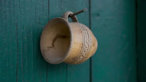 Old wooden jug with an abstract pattern hanging on a metal nail Stock Footage 158763956