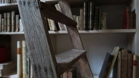 Old wooden ladder with a bookcase full of old books behind it. In the bookstore Stock Footage